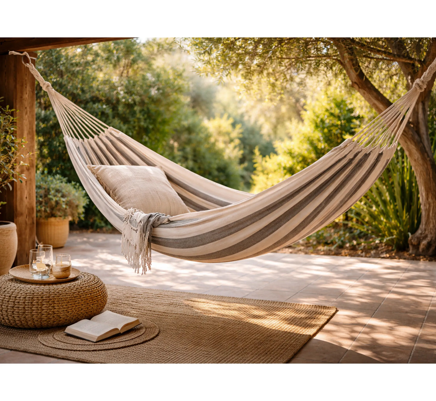 Hamaca BAHAMAS instalada en un porche de madera, creando un rincón de bienestar y lectura.