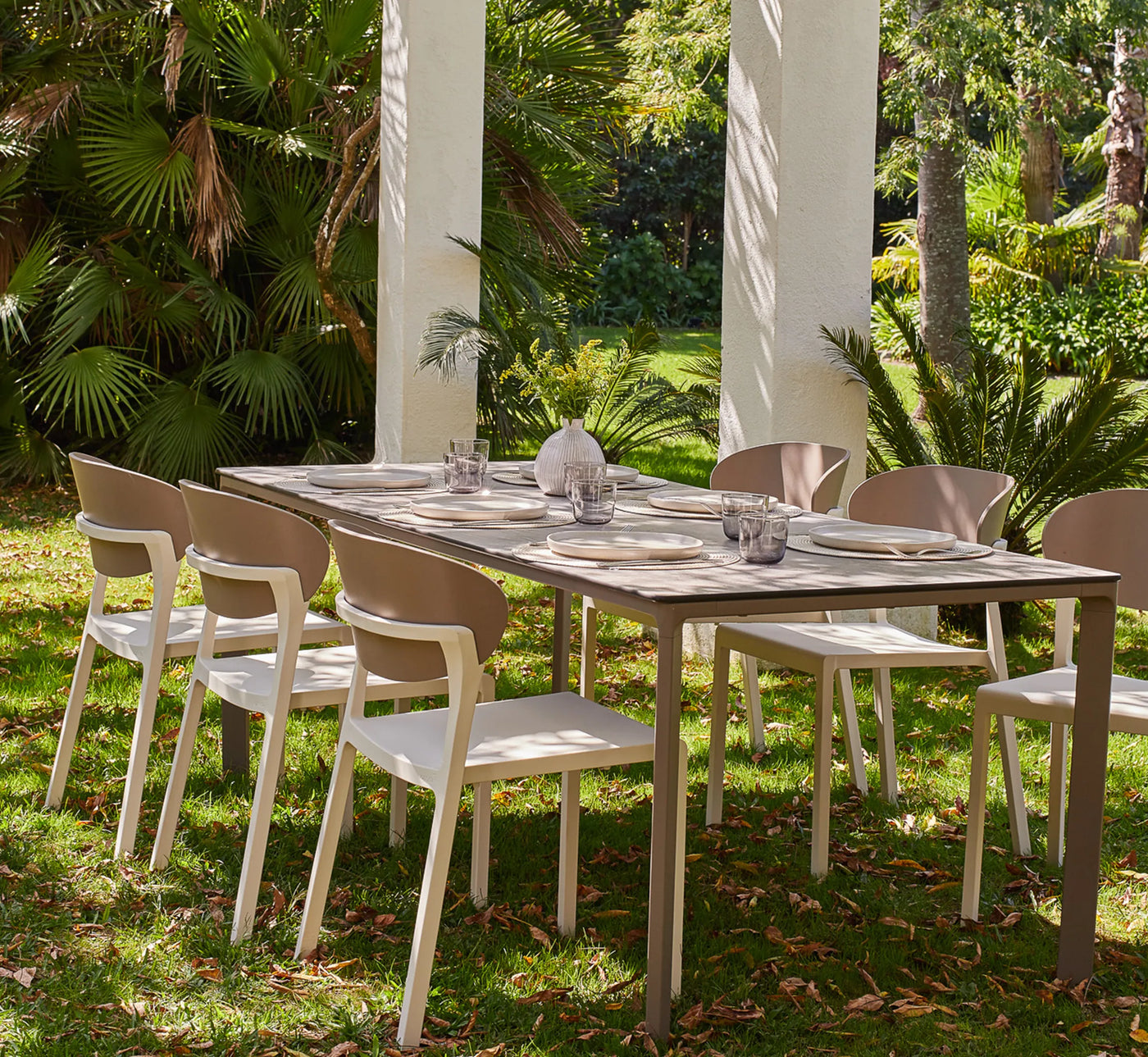 Mesa MEET rectangular con seis sillas BAKE, configurando un comedor exterior amplio, luminoso y de diseño exclusivo.