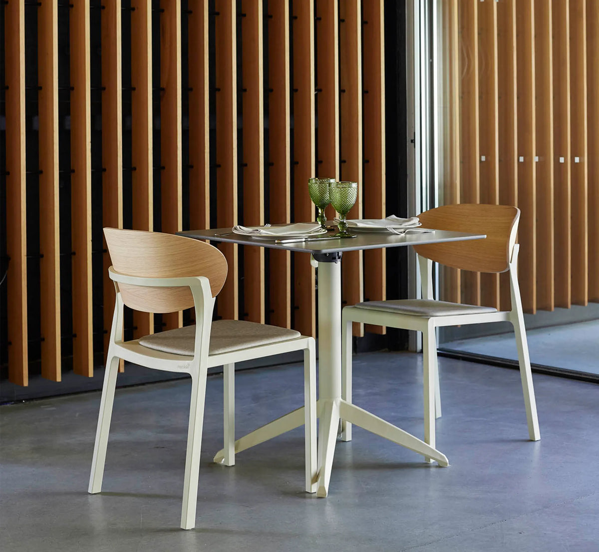 Conjunto de sillas BAKE WOOD en la terraza cubierta de un restaurante de diseño.