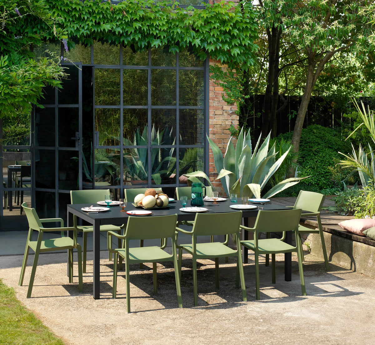 Comedor de exterior con sillas TRILL rodeando una mesa de diseño minimalista.