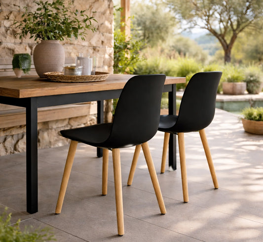 Dos sillas ANCA alrededor de una mesa de comedor de madera en un porche cubierto.