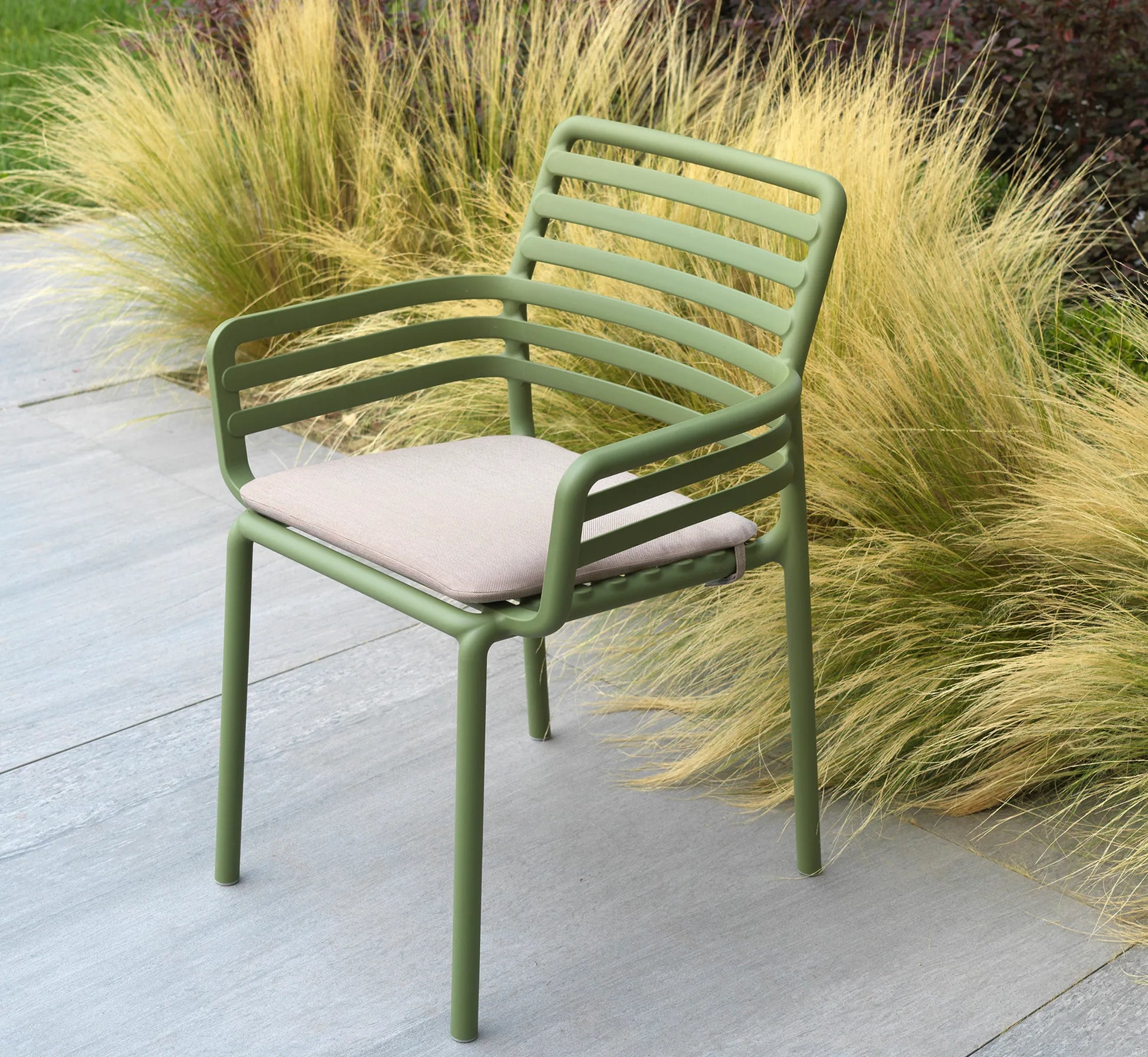 Silla DOGA Armchair con su cojín instalado en una terraza de estilo contemporáneo.