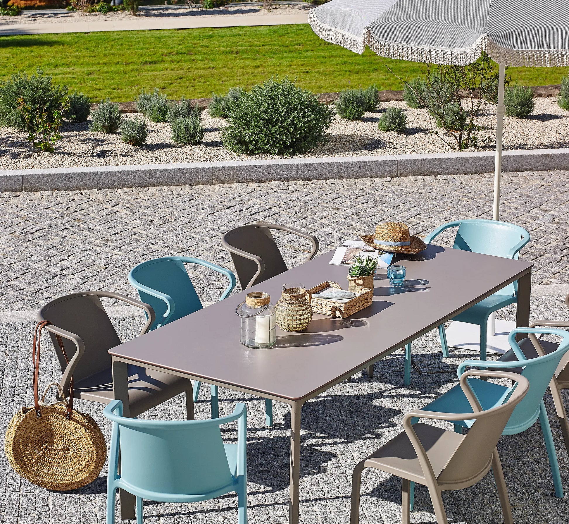 Mesa MEET rectangular en la terraza de un hotel boutique, mostrando su elegancia y gran capacidad para 8 comensales.