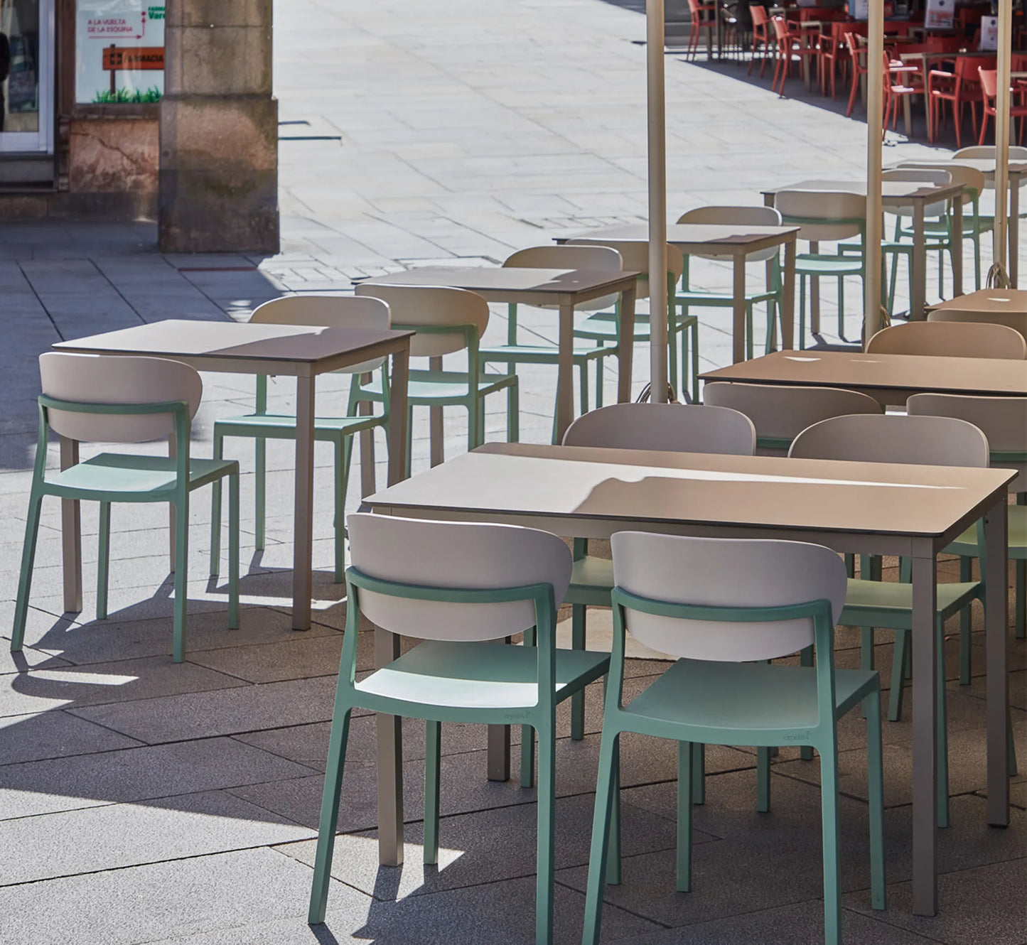 Mesa MÓNACO acompañada de sillas Bake en una terraza de diseño, creando un comedor exterior amplio y sofisticado.