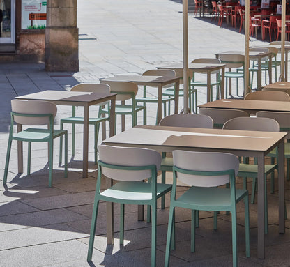 Mesa MÓNACO acompañada de sillas Bake en una terraza de diseño, creando un comedor exterior amplio y sofisticado.