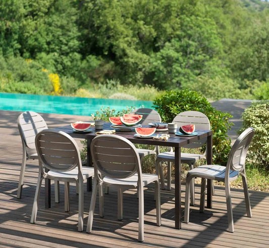 Mesa CUBE de 120 cm con sillas de la colección Nardi, creando un comedor de exterior ordenado y sofisticado en una terraza moderna.