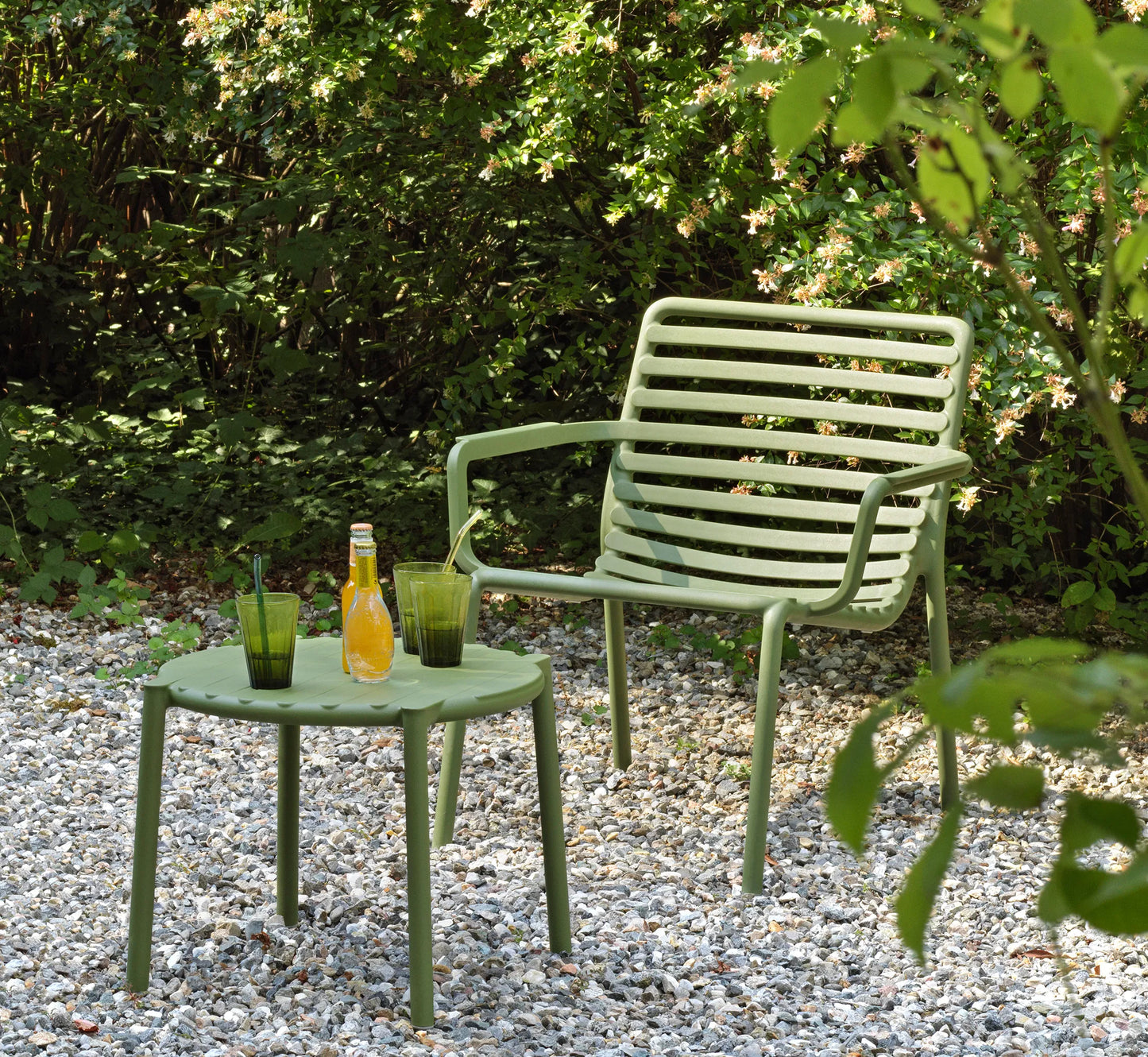 Mesa baja DOGA de NARDI en color verde junto a un sillón relax.