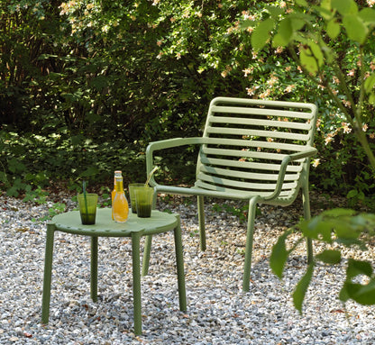 Mesa baja DOGA de NARDI en color verde junto a un sillón relax.