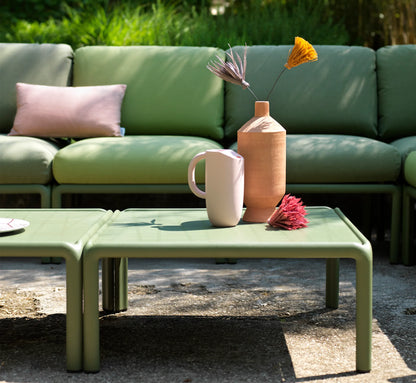 Mesa KOMODO integrada en un sofá modular de la misma serie en una terraza de diseño.
