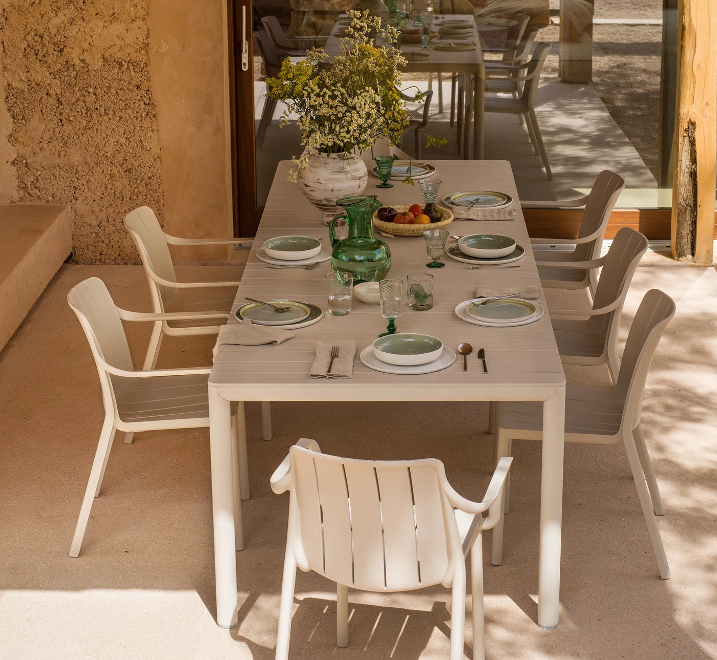 Mesa TEVERE extendida para 8 plazas, creando un comedor exterior amplio y acogedor.