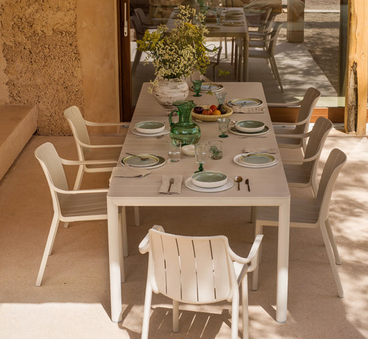 Mesa TEVERE extendida para 8 plazas, creando un comedor exterior amplio y acogedor.