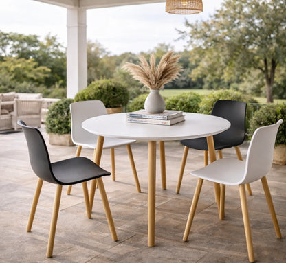 Mesa BUMBA rodeada de cuatro sillas de diseño, creando un ambiente de comedor equilibrado y acogedor.