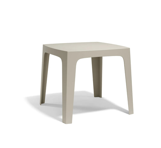 Mesa SOLID de Vondom en color ecru, destacando su diseño monobloc orgánico y su acabado mate de alta calidad.