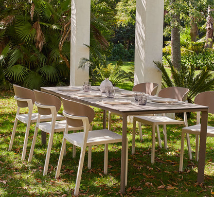 Mesa MEET rectangular con seis sillas BAKE, configurando un comedor exterior amplio, luminoso y de diseño exclusivo.