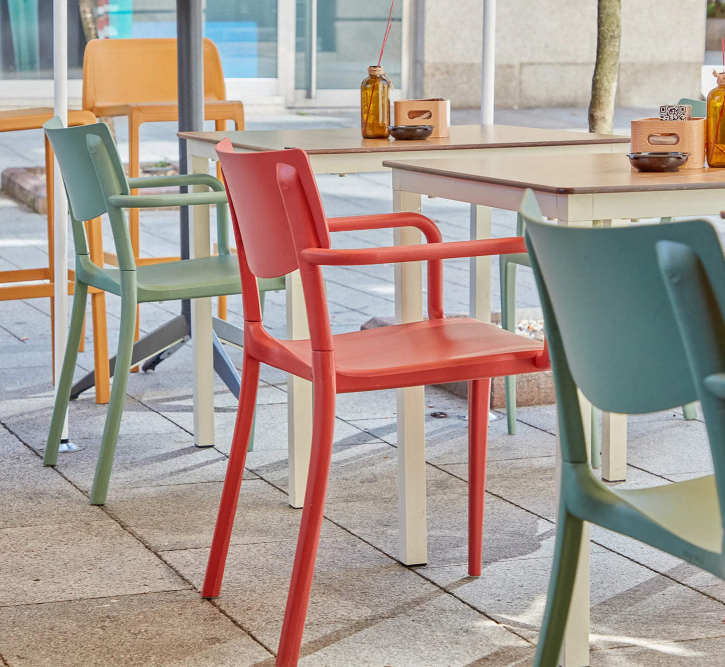 Conjunto de sillas TOWN de diferentes colores en una terraza urbana moderna.