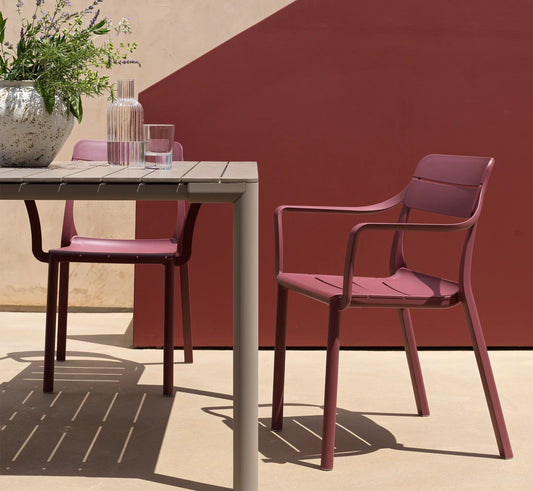 Conjunto de sillas CASSIA con brazos en una terraza.