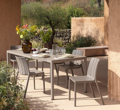 Conjunto de sillas TIBERINA en una terraza de diseño rodeada de naturaleza.