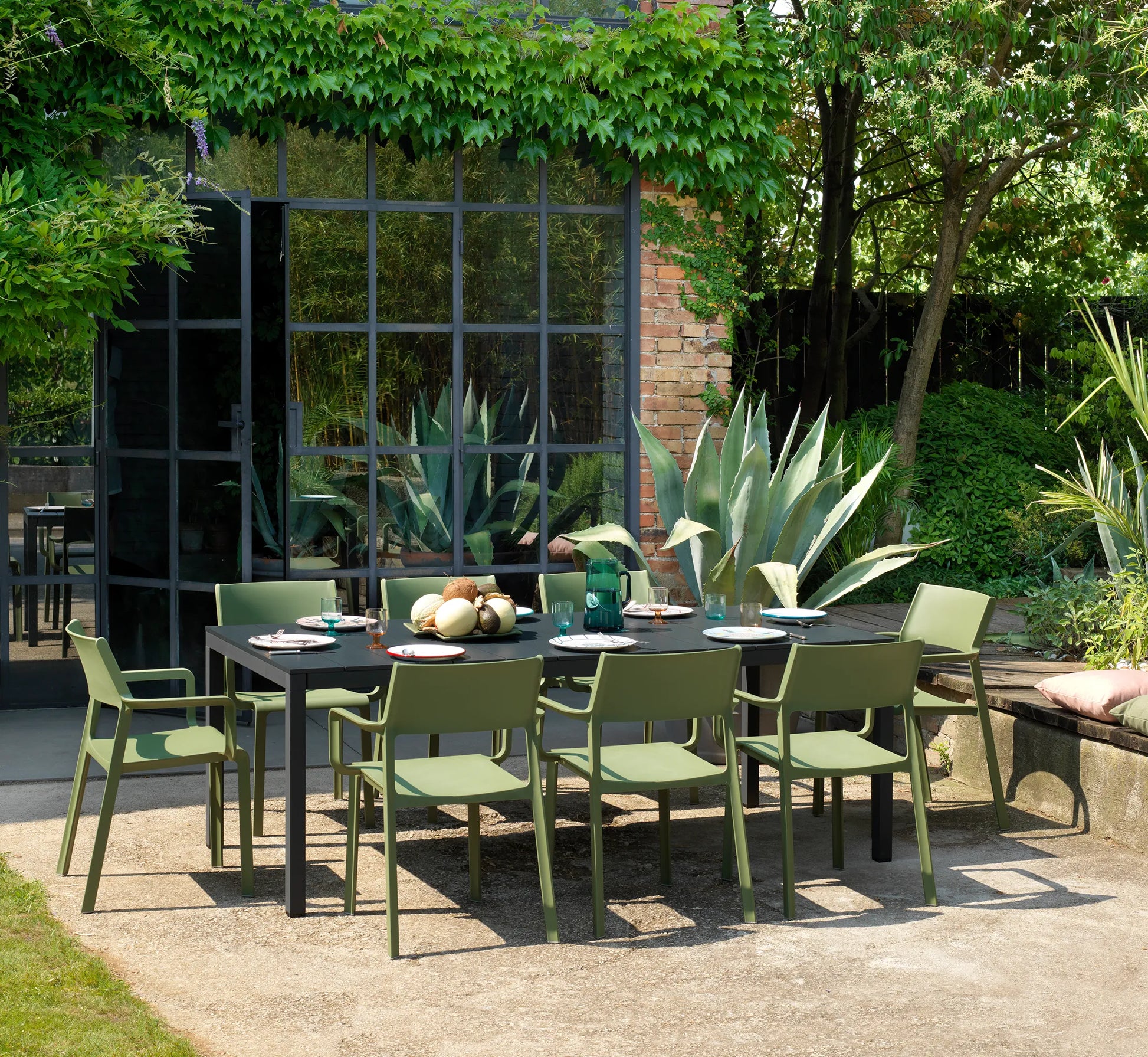 Comedor de exterior con sillas TRILL rodeando una mesa de diseño minimalista.