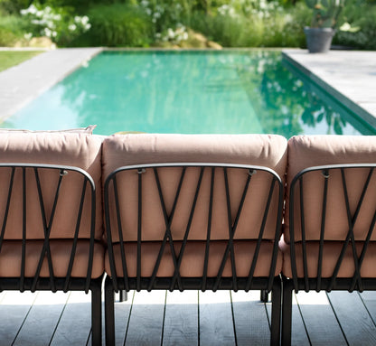 onfiguración de sofá de exterior usando elementos centrales Komodo, creando una zona de bienestar continua.