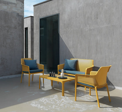 Varios sillones NET RELAX dispuestos alrededor de una mesa baja en una terraza, creando un ambiente lounge sofisticado.