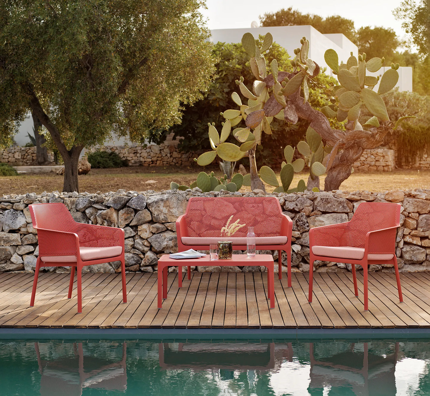 Conjunto piezas NET de Nardi en una terraza de diseño, resaltando su estética coral y ligereza.