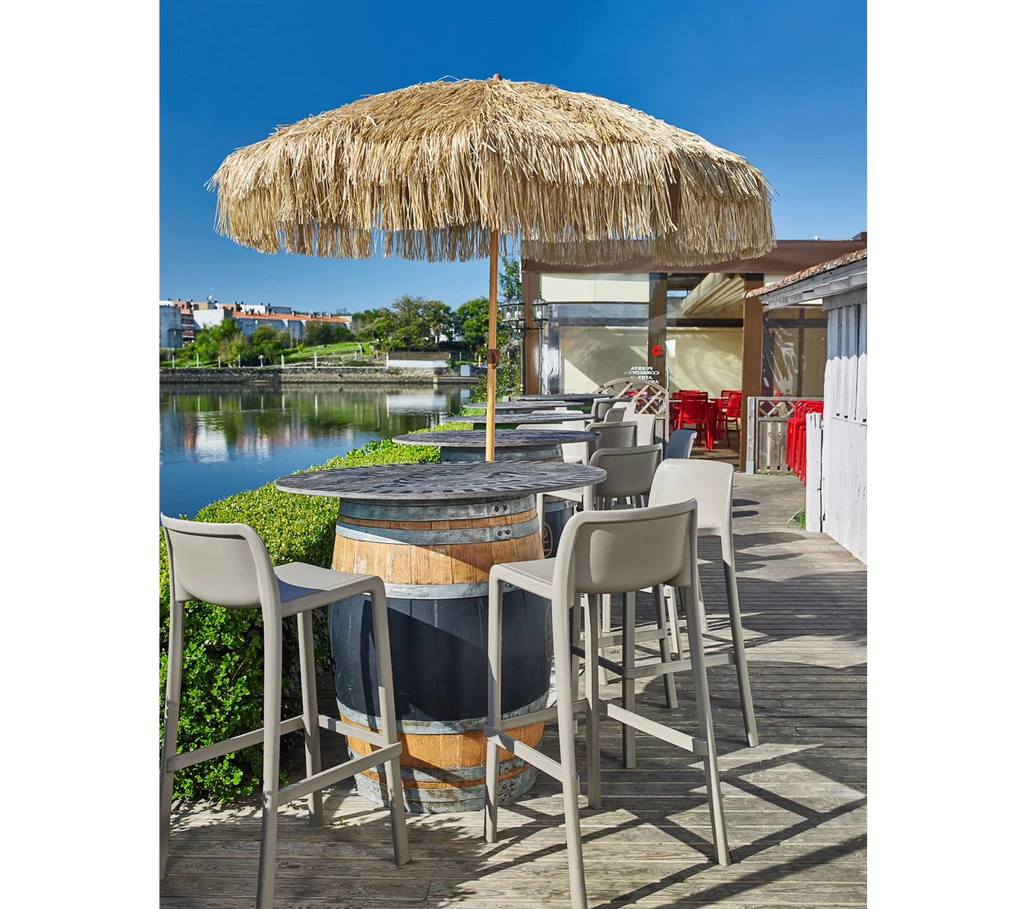 Sombrilla de Ezpeleta MANILA en la terraza de un restaurante frente al mar.
