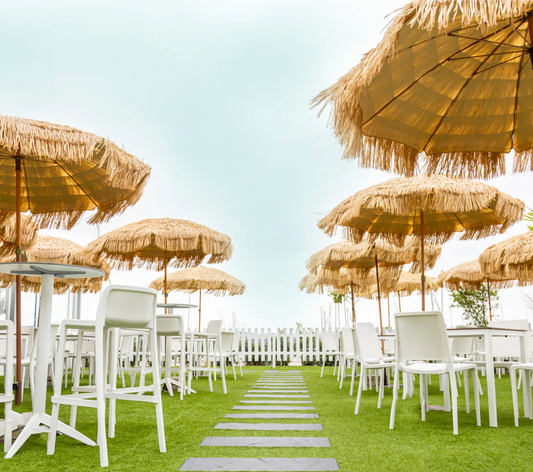 Sombrilla tropical MANILA en la terraza de un restaurante frente al mar.