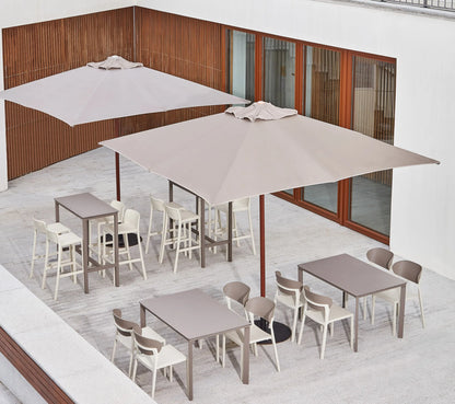 Sombrilla cuadrada JAVA en una terraza de hostelería frente al mar.